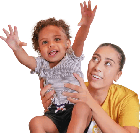 A smiling young child with an AIA team member
